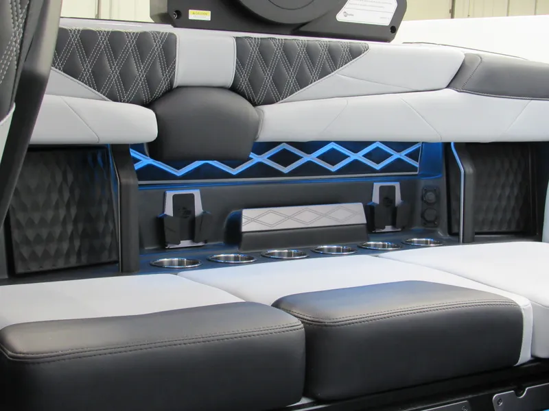 Slide: The Image of 2025 Malibu M230 interior with modern seating, cup holders, and ambient blue lighting. - 12