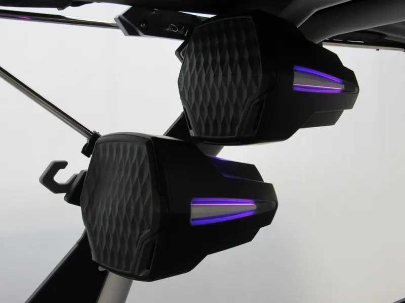 Slide: The Image of Speakers with purple LED lights in a 2025 Malibu M230 boat interior. - 21