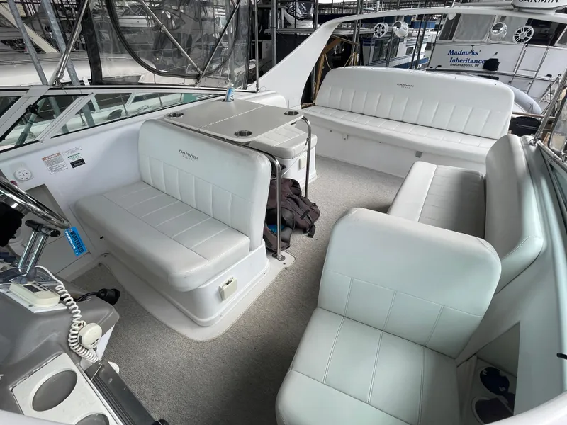 Slide: The Image of 2002 Carver 350 Mariner interior with white seating and helm, docked in marina. - 15