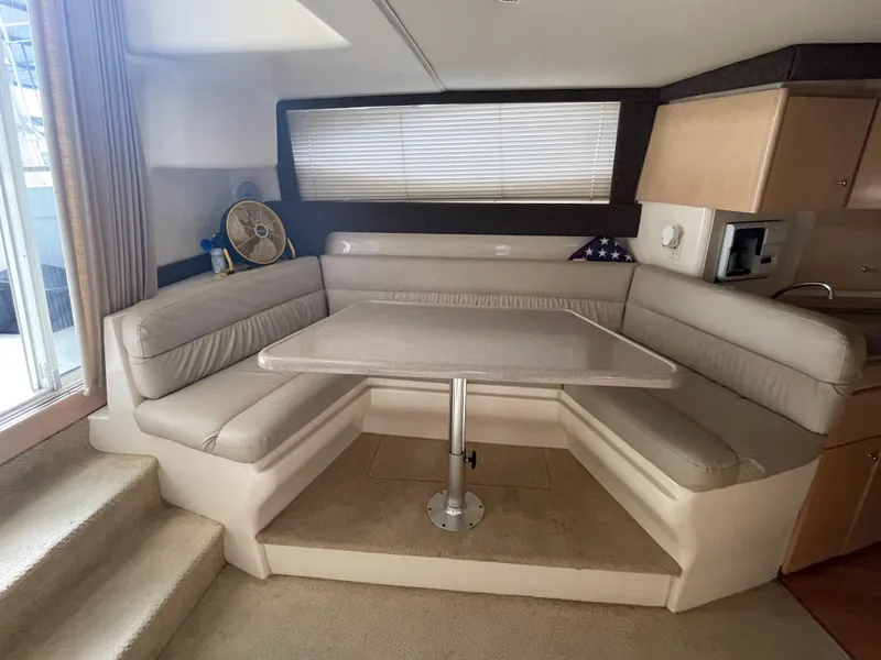 Slide: The Image of Interior of 2002 Carver 350 Mariner yacht with cozy dining area and plush seating. - 22