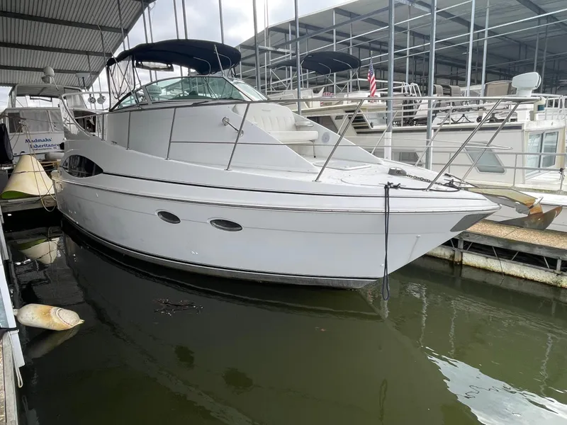 Slide: The Image of 2002 Carver 350 Mariner yacht docked in marina, featuring sleek white design. - 4