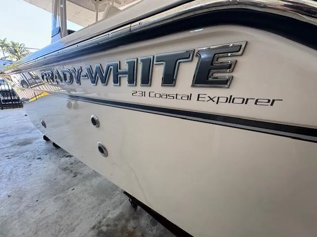 Slide: The Image of 2025 Grady-White 231 Coastal Explorer boat side view with logo. - 11
