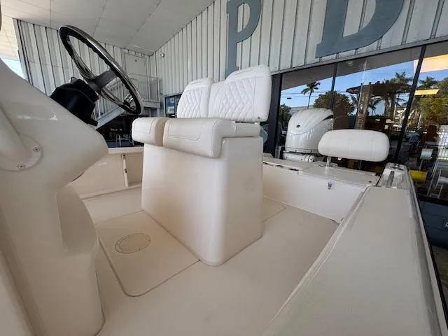 Slide: The Image of 2025 Grady-White 231 Coastal Explorer boat interior with white seating and steering wheel. - 8