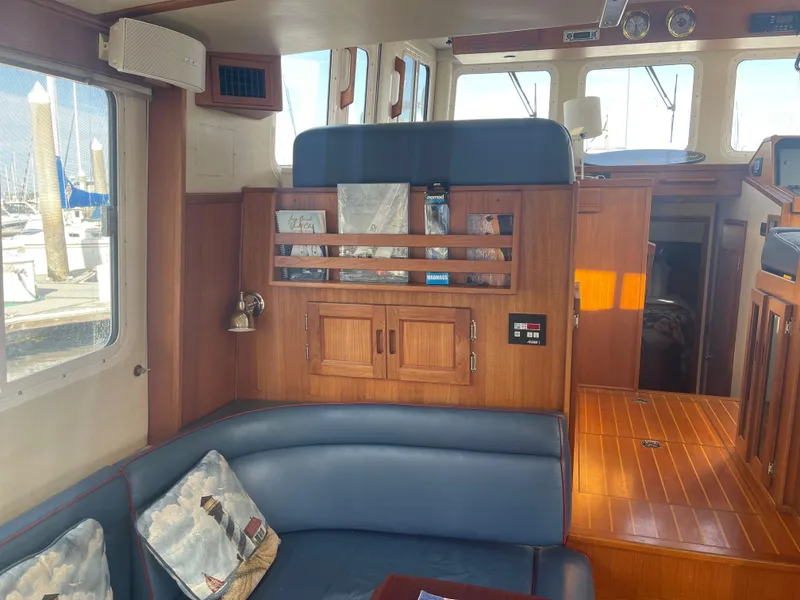 Slide: The Image of Interior of 2005 Nordic Tug 37 with wood paneling and blue seating. - 10