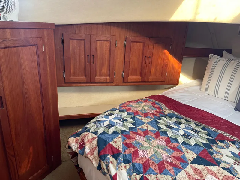 Slide: The Image of Cozy cabin interior of 2005 Nordic Tug 37 with quilted bedspread and wooden cabinets. - 19