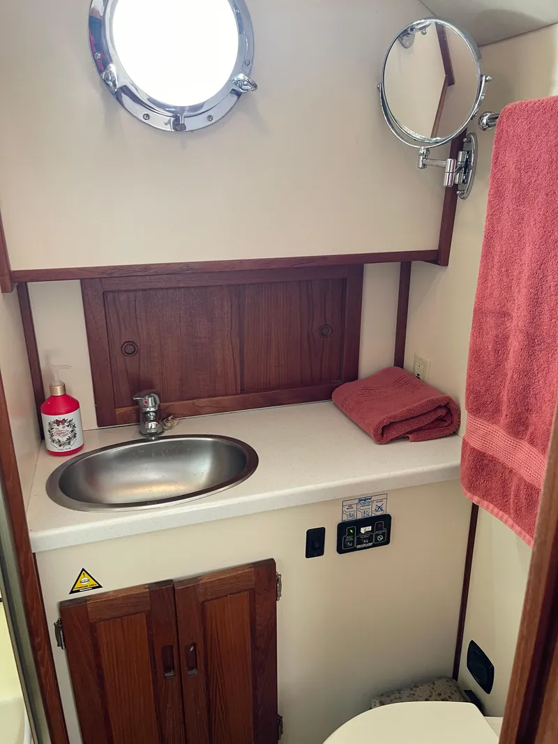 Slide: The Image of 2005 Nordic Tug 37 bathroom with sink, mirror, and red towel. - 21