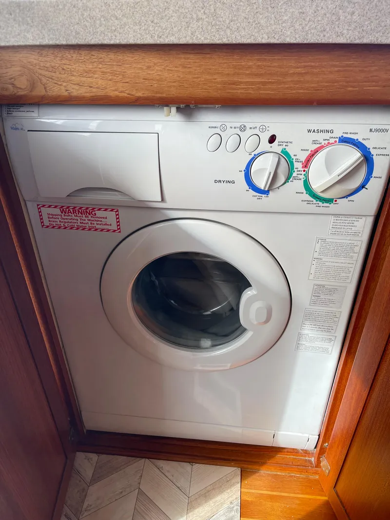 Slide: The Image of Washing machine inside a 2005 Nordic Tug 37 boat, compactly installed under a counter. - 24