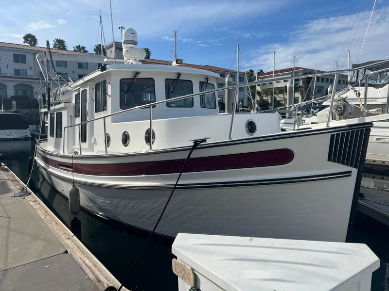Slide: The Image of 2005 Nordic Tug 37 docked at marina under clear blue sky. - 29