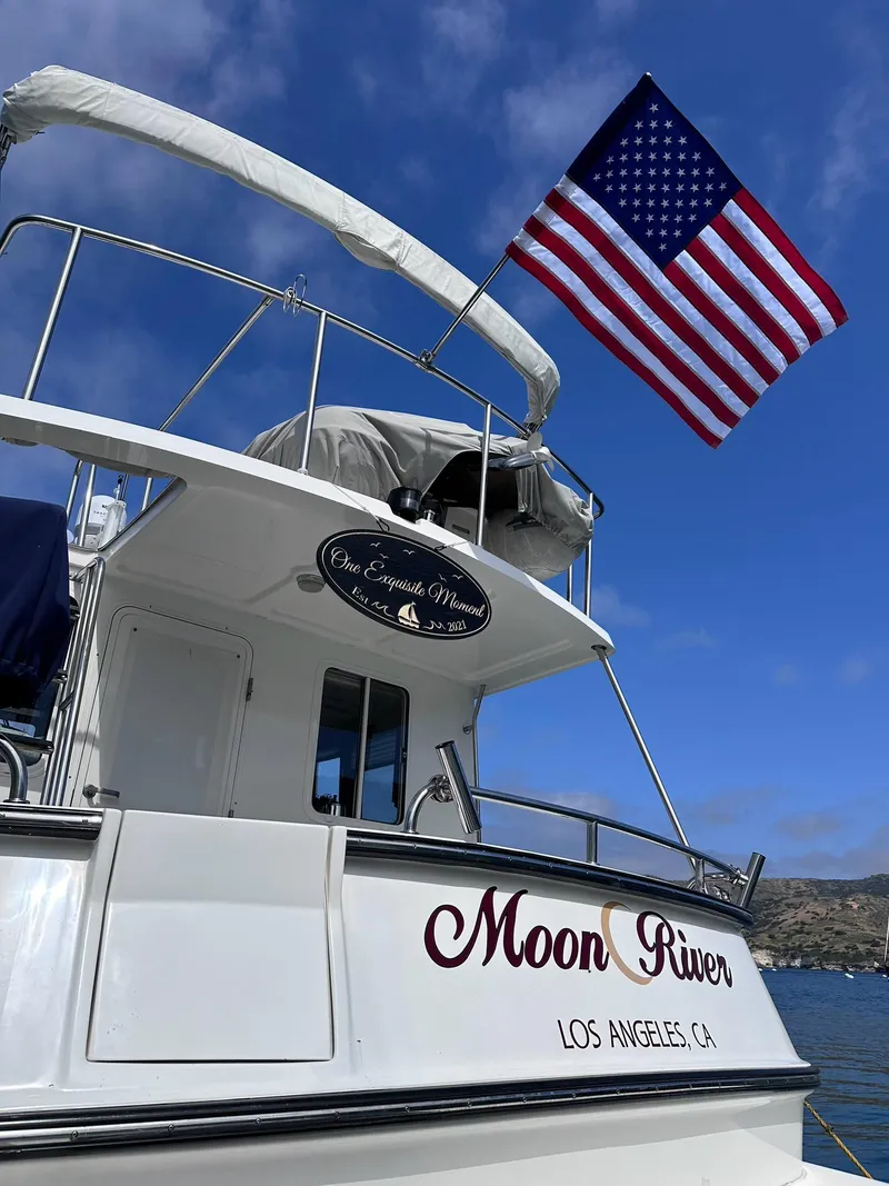 Slide: The Image of 2005 Nordic Tug 37 boat named "Moon River" with American flag, Los Angeles, CA. - 3