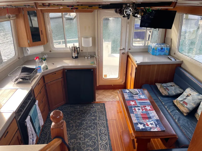 Slide: The Image of Interior of a 2005 Nordic Tug 37, featuring a cozy kitchen and seating area. - 9