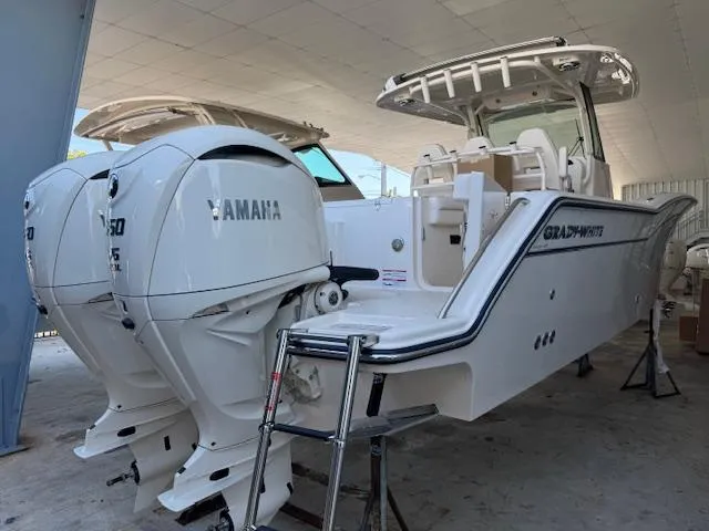 Slide: The Image of 2025 Grady-White Canyon 326 boat with twin Yamaha engines in a covered area. - 1