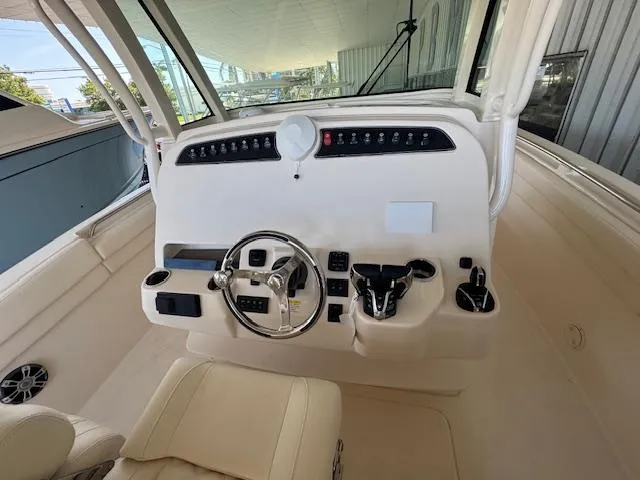 Slide: The Image of 2025 Grady-White Canyon 326 boat helm with steering wheel and controls. - 13