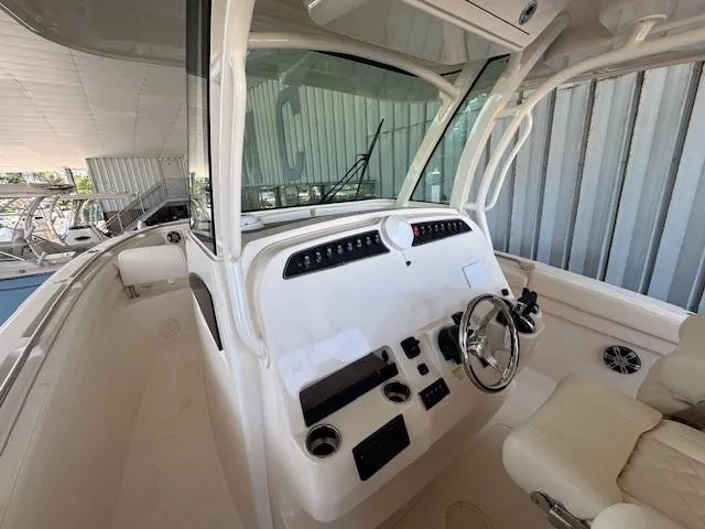 Slide: The Image of 2025 Grady-White Canyon 326 boat cockpit with steering wheel and control panel. - 22