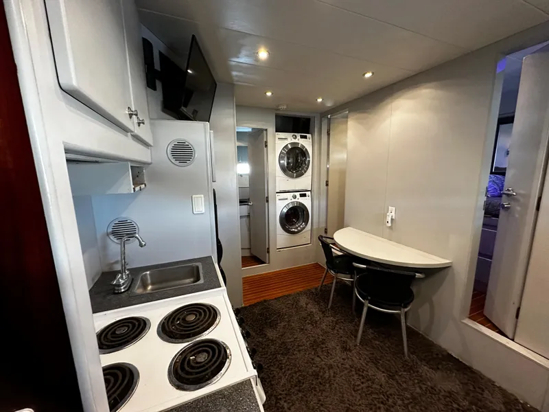 Slide: The Image of Compact kitchen and dining area in 1996 Monte Fino 92 MY yacht, featuring modern appliances. - 38