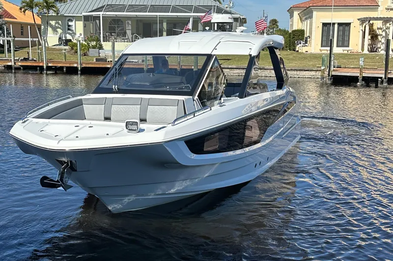Slide: The Image of 2022 Galeon 325 GTO luxury yacht on calm water near docks. - 28