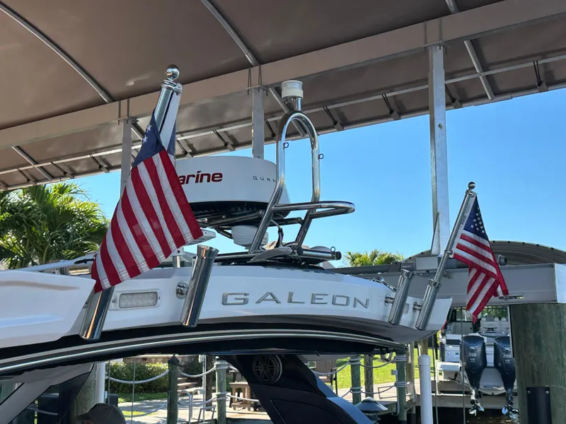 Slide: The Image of 2022 Galeon 325 GTO yacht with American flags, docked under a canopy. - 35
