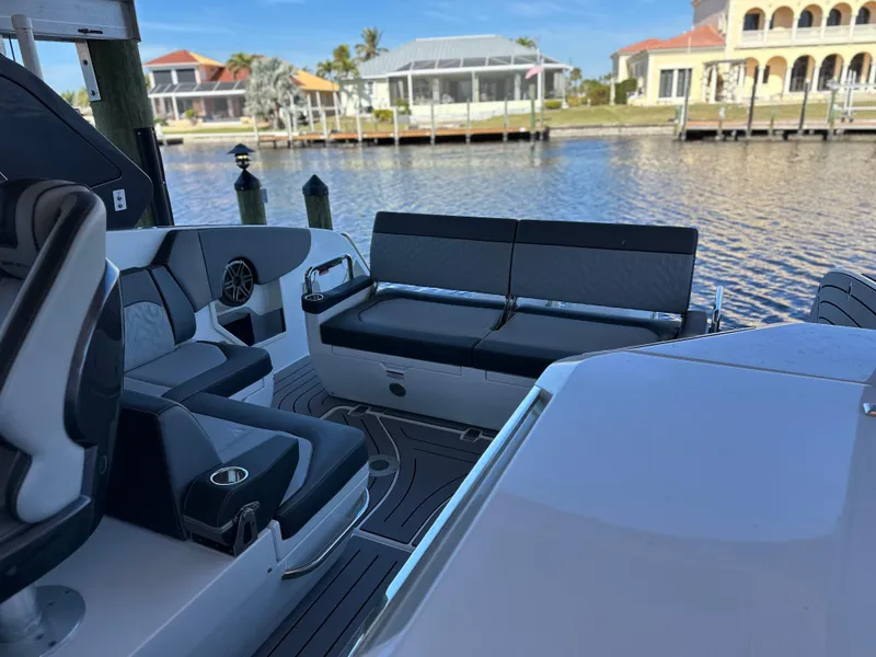 Slide: The Image of 2022 Galeon 325 GTO boat interior with seating, docked by waterfront homes. - 49