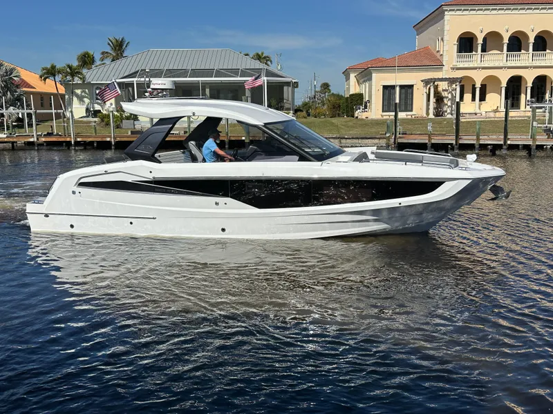 Slide: The Image of 2022 Galeon 325 GTO luxury yacht cruising on a sunny waterfront. - 5