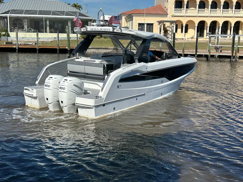 Slide: The Image of 2022 Galeon 325 GTO yacht with triple engines cruising near waterfront homes. - 6