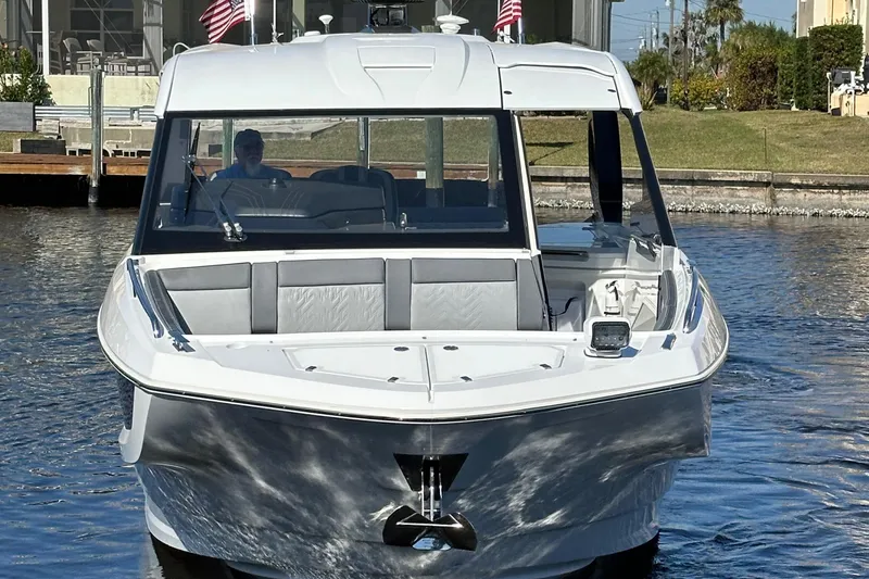Slide: The Image of 2022 Galeon 325 GTO yacht on water, front view with American flags. - 7