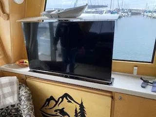 Slide: The Image of Interior of a 1995 Navigator 50 yacht with a TV and marina view. - 12