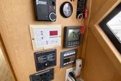 Slide: The Image of Control panel of a 1995 Navigator 50 yacht with various gauges and displays. - 35