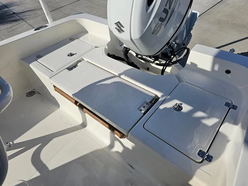 Slide: The Image of 2025 Pioneer 220 Bay Sport boat deck with Suzuki outboard motor, featuring storage compartments. - 10
