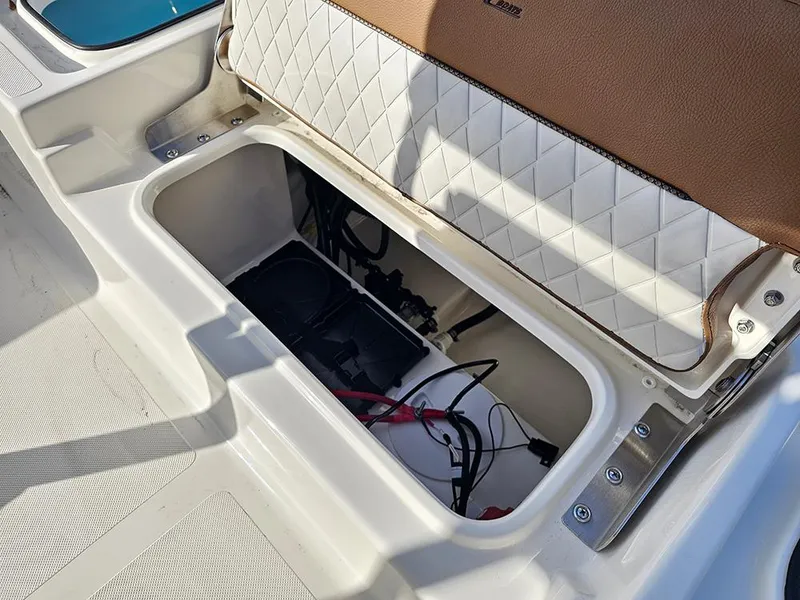 Slide: The Image of Storage compartment of 2025 Pioneer 220 Bay Sport boat with wiring and quilted seat. - 12