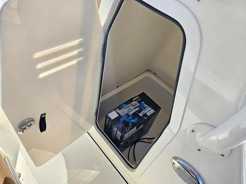 Slide: The Image of Open storage compartment on 2025 Pioneer 220 Bay Sport boat with battery inside. - 18