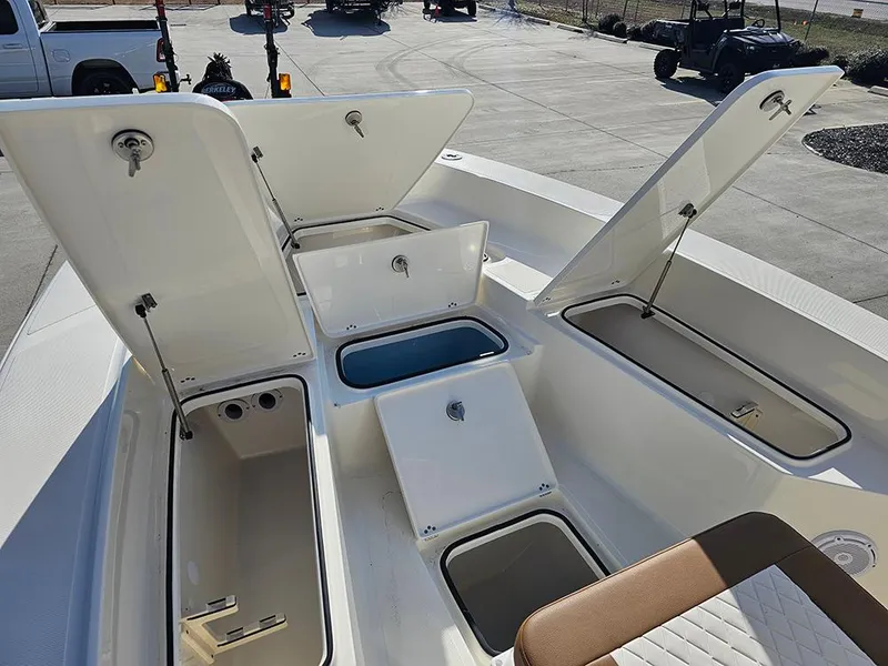 Slide: The Image of 2025 Pioneer 220 Bay Sport boat with open storage compartments and seating. - 20