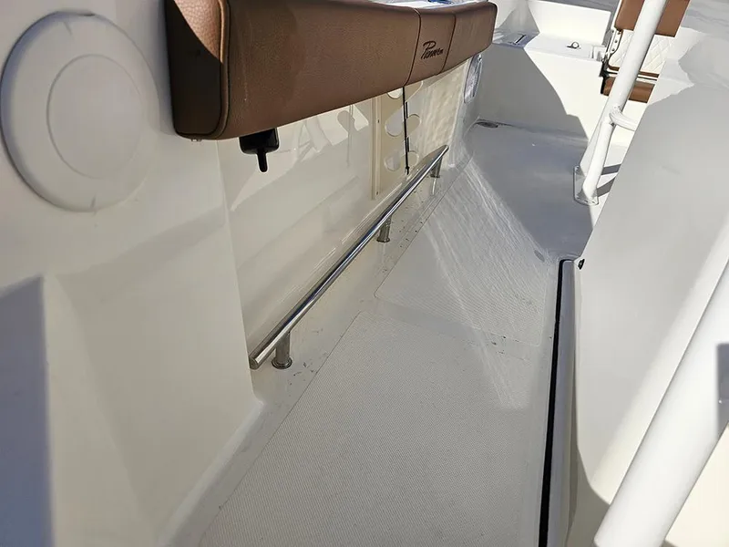 Slide: The Image of 2025 Pioneer 220 Bay Sport boat interior with cushioned seating and stainless steel railing. - 23