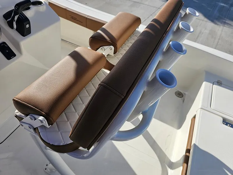 Slide: The Image of 2025 Pioneer 220 Bay Sport boat seating with rod holders and brown cushions. - 26