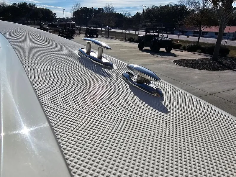 Slide: The Image of 2025 Pioneer 220 Bay Sport boat deck with cleats in a sunny outdoor setting. - 30