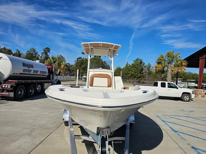 Slide: The Image of 2025 Pioneer 220 Bay Sport boat on trailer, parked outdoors under clear blue sky. - 4