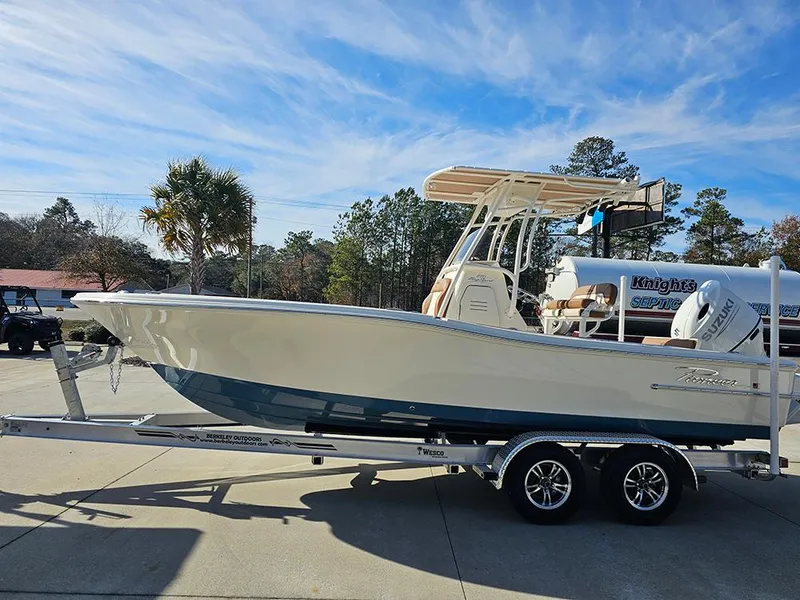 Slide: The Image of 2025 Pioneer 220 Bay Sport boat on trailer, parked outdoors under a clear blue sky. - 6