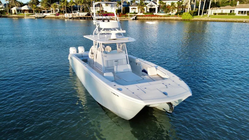 Slide: The Image of 2019 Invincible 37 Catamaran on calm water near a coastal residential area. - 14