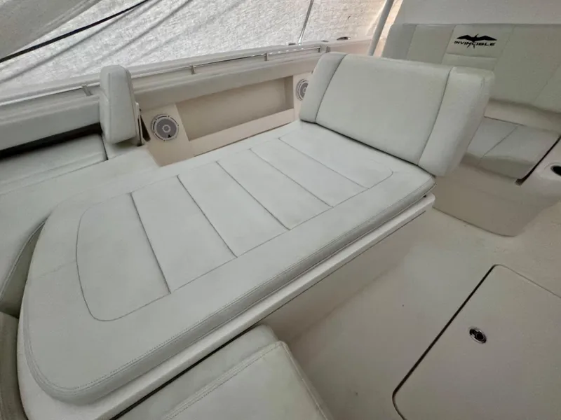 Slide: The Image of 2019 Invincible 37 Catamaran interior with white cushioned seating and built-in speakers. - 20