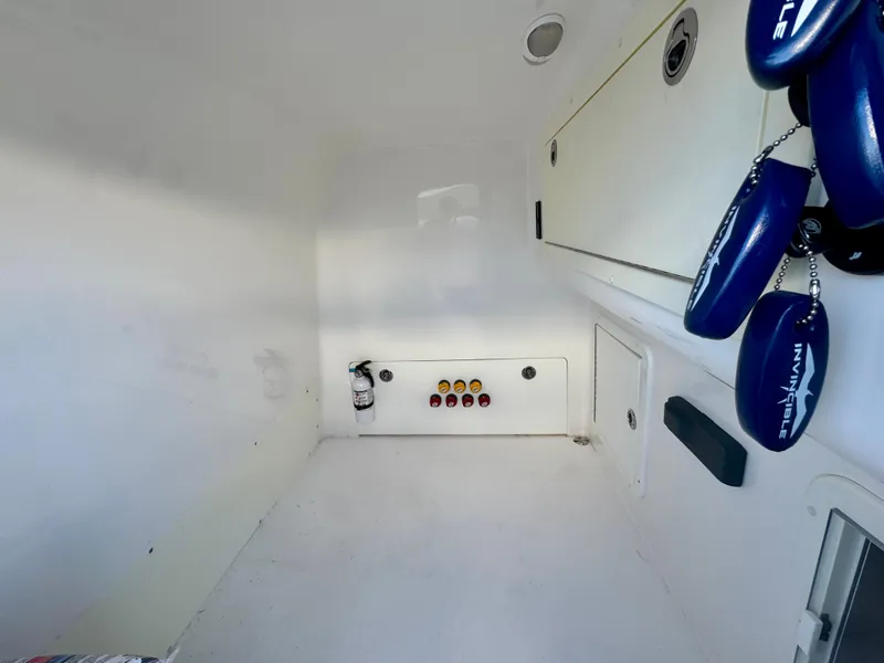 Slide: The Image of 2019 Invincible 37 Catamaran interior storage compartment with control panel and hanging accessories. - 25