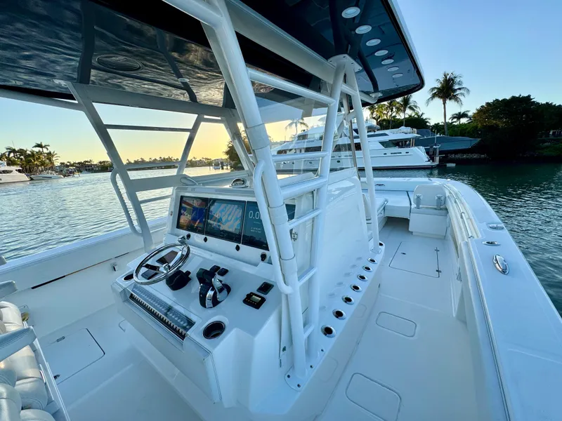 Slide: The Image of 2019 Invincible 37 Catamaran with modern helm, docked in scenic marina at sunset. - 45