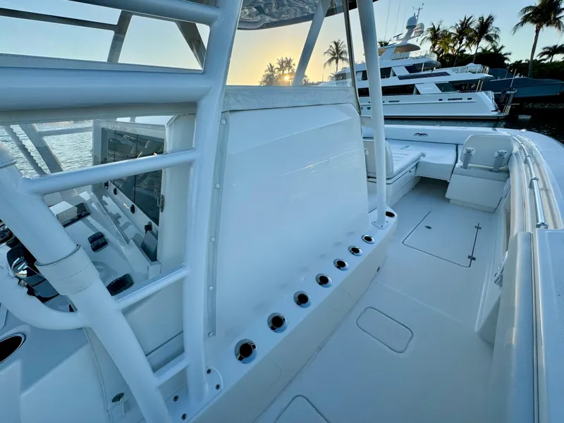 Slide: The Image of 2019 Invincible 37 Catamaran, sleek deck view, docked with palm trees in background. - 46