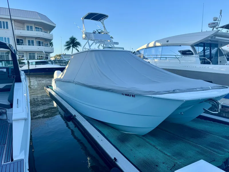 Slide: The Image of 2019 Invincible 37 Catamaran docked, covered, with nearby yachts and waterfront buildings. - 79
