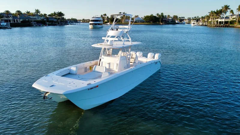 Slide: The Image of 2019 Invincible 37 Catamaran on calm water, surrounded by scenic waterfront homes. - 9