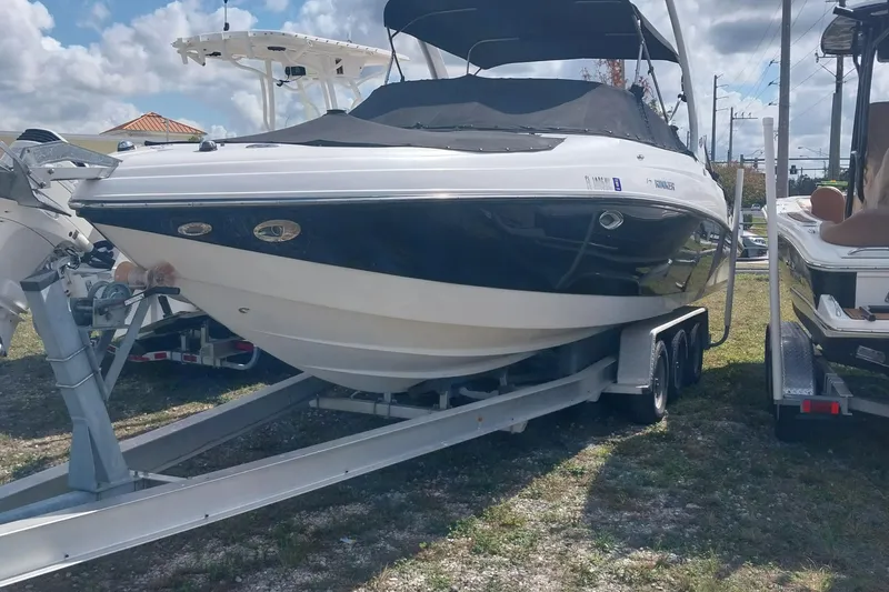 The Image of 2009 Rinker 296 Captiva Bowrider on trailer, black and white, parked outdoors. - 1