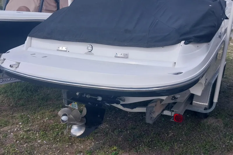 Slide: The Image of 2009 Rinker 296 Captiva Bowrider boat, rear view with covered deck and visible propeller. - 3