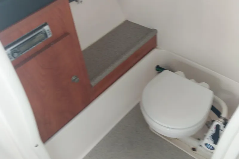 Slide: The Image of 2009 Rinker 296 Captiva Bowrider interior with compact marine toilet and storage. - 6