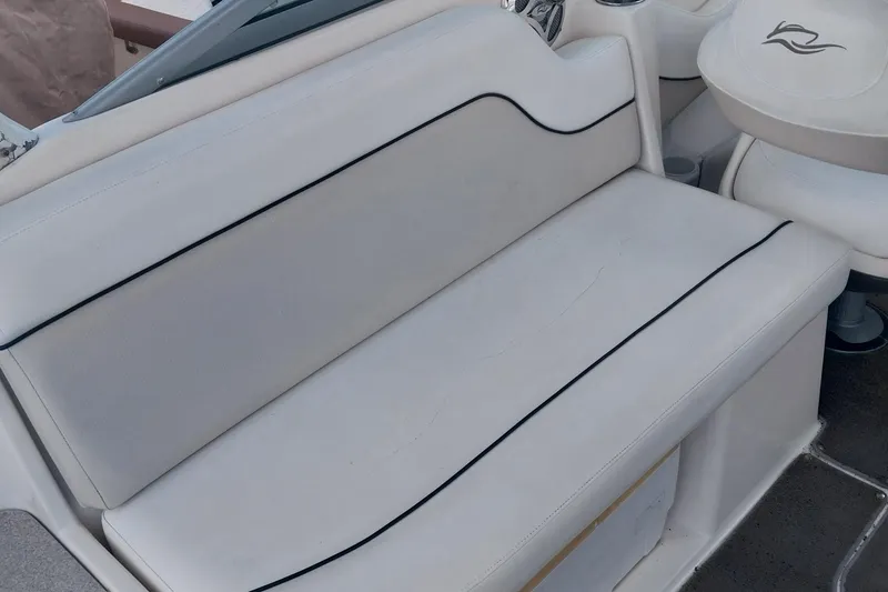 Slide: The Image of 2009 Rinker 296 Captiva Bowrider interior seating with white upholstery and black trim. - 8