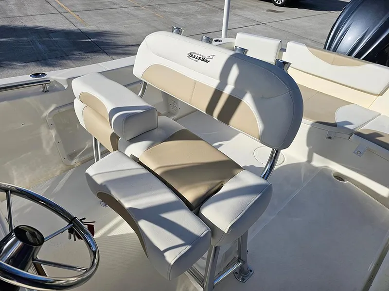 Slide: The Image of 2025 Bulls Bay 230 Center Console boat interior with beige and white seating. - 17