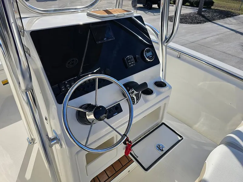 Slide: The Image of 2025 Bulls Bay 230 Center Console boat dashboard with steering wheel and controls. - 19