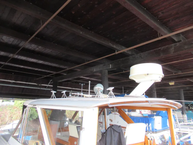 Slide: The Image of 1963 Chris-Craft Constellation boat under a wooden dock, showcasing radar equipment. - 10