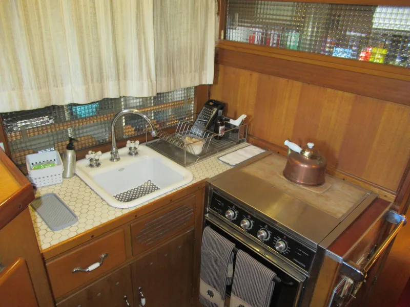 Slide: The Image of 1963 Chris-Craft Constellation kitchen with vintage stove, sink, and wooden cabinetry. - 15